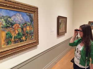 Susan studies Cezanne artwork with monocular at the Baltimore Museum of Art