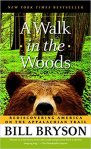 image of the book cover of Bill Bryson's A Walk in the Woods is a forest and the head of a bear peeking into view at the bottom of the frame.